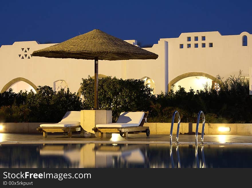 Couch and sunshade near swimming pool