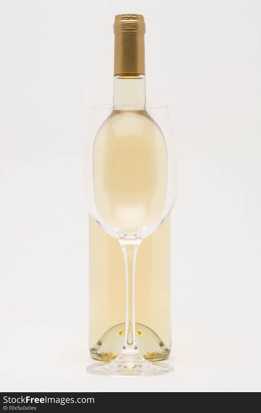 Isolated white wine bottle with empty glass in front