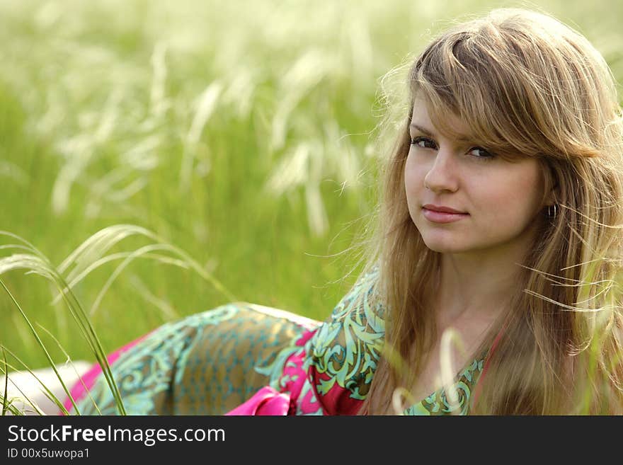 Vivid picture of nice young lady relaxing at summer meadow. Vivid picture of nice young lady relaxing at summer meadow