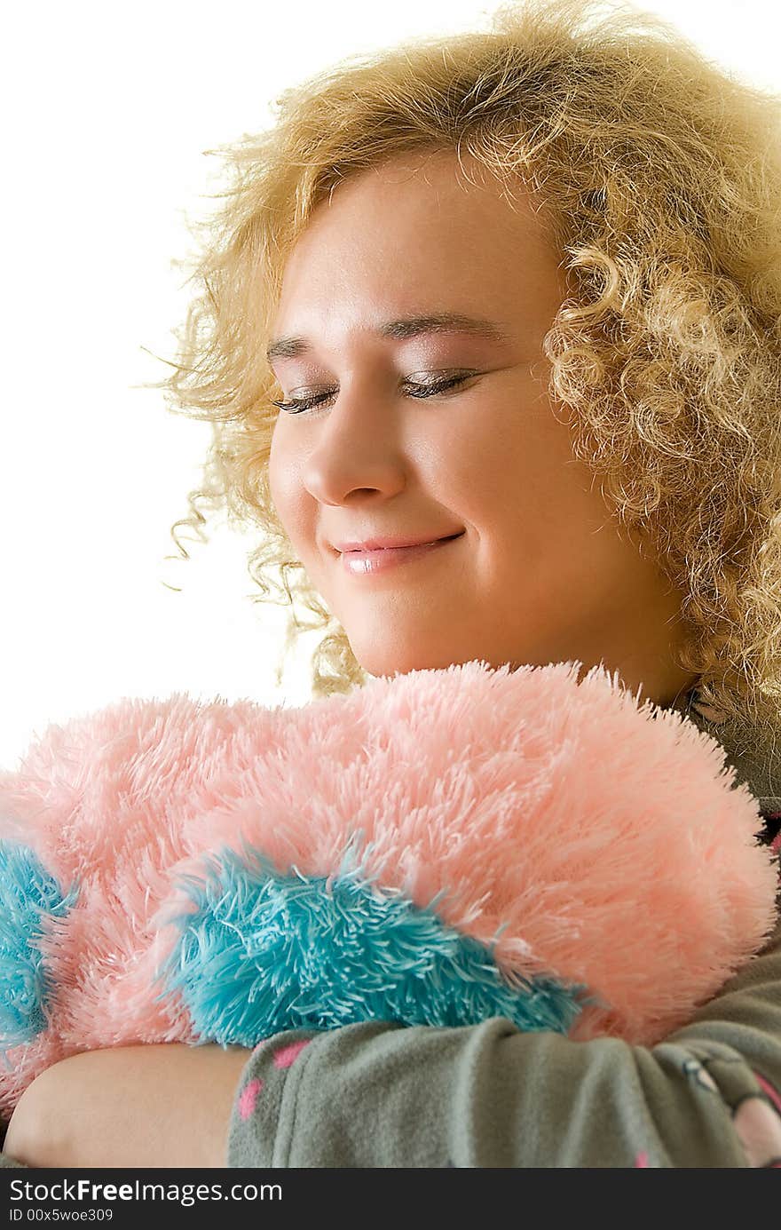 Young woman with closed eyes embracing a pillow. Young woman with closed eyes embracing a pillow