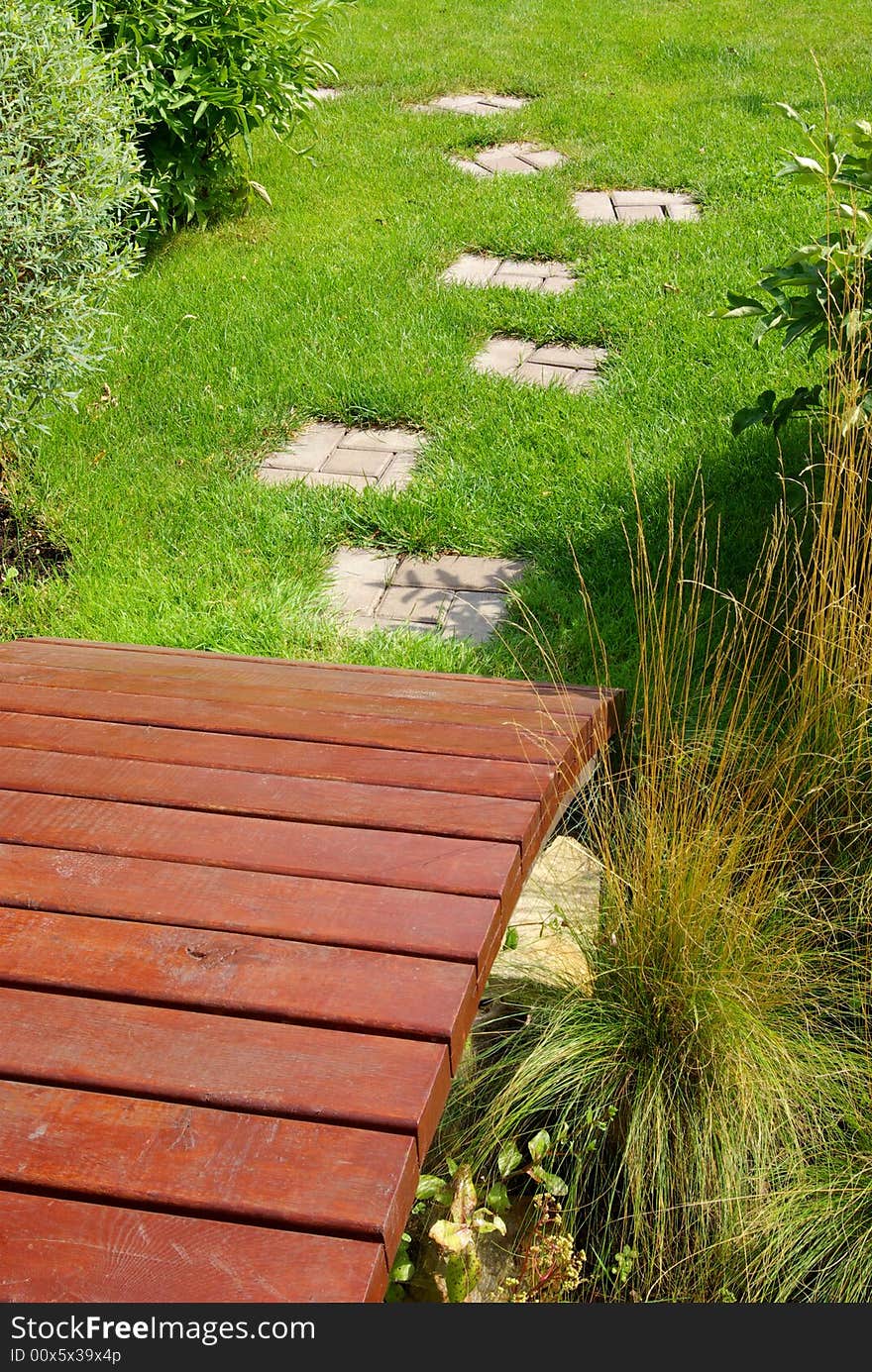 Garden stone path with grass growing up between the stones