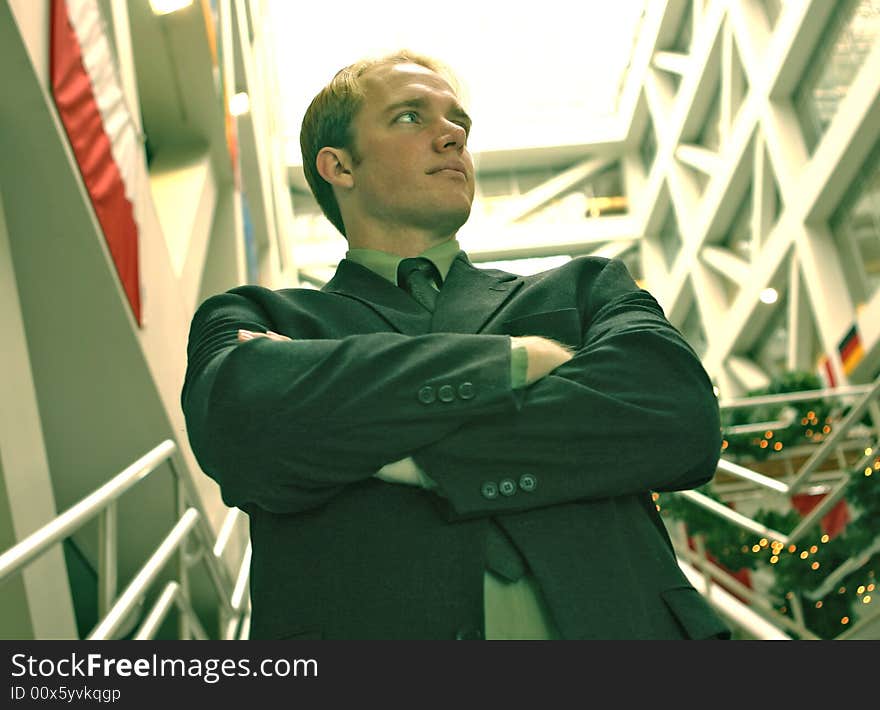 Confident businessman standing with his arms folded in an office building