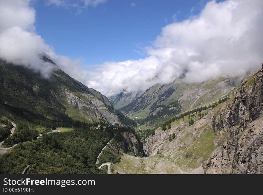 Swiss mountain landscape, clouds and green rocky slopes, Alps, Switzerland.