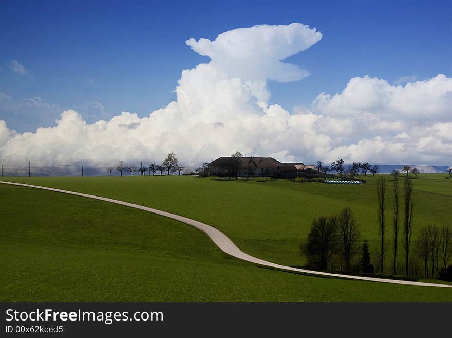 Landscape with farmhouse and dramatic cloudscape. Landscape with farmhouse and dramatic cloudscape