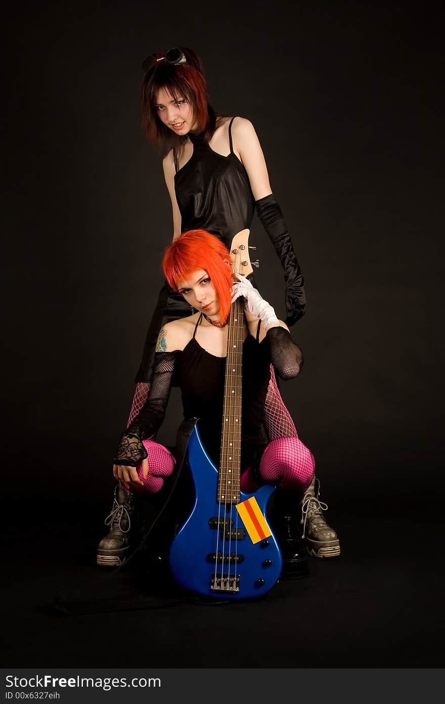 Rock girls with guitar isolated in studio. Rock girls with guitar isolated in studio