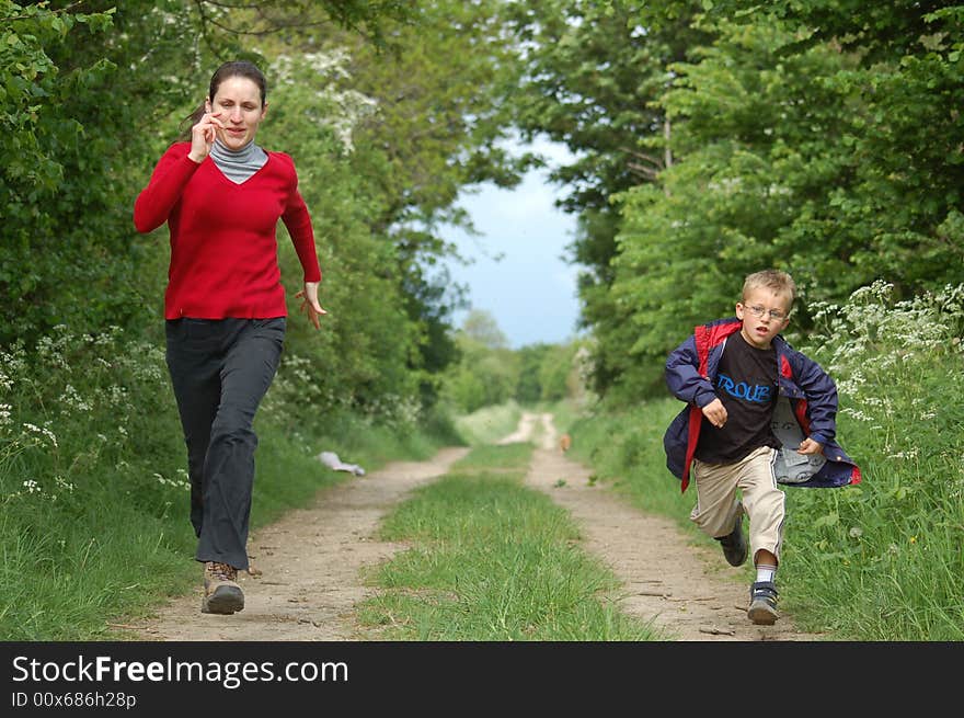 A mother and son having a race along a country path. A mother and son having a race along a country path