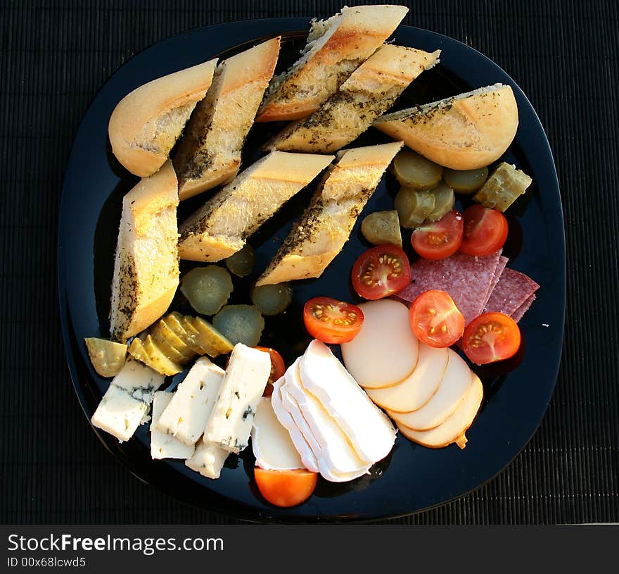 A lot of food on the black plate. A lot of food on the black plate