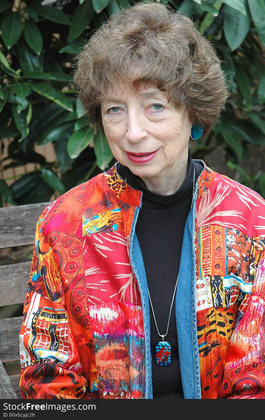 Mature female senior relaxing at home on her patio deck.