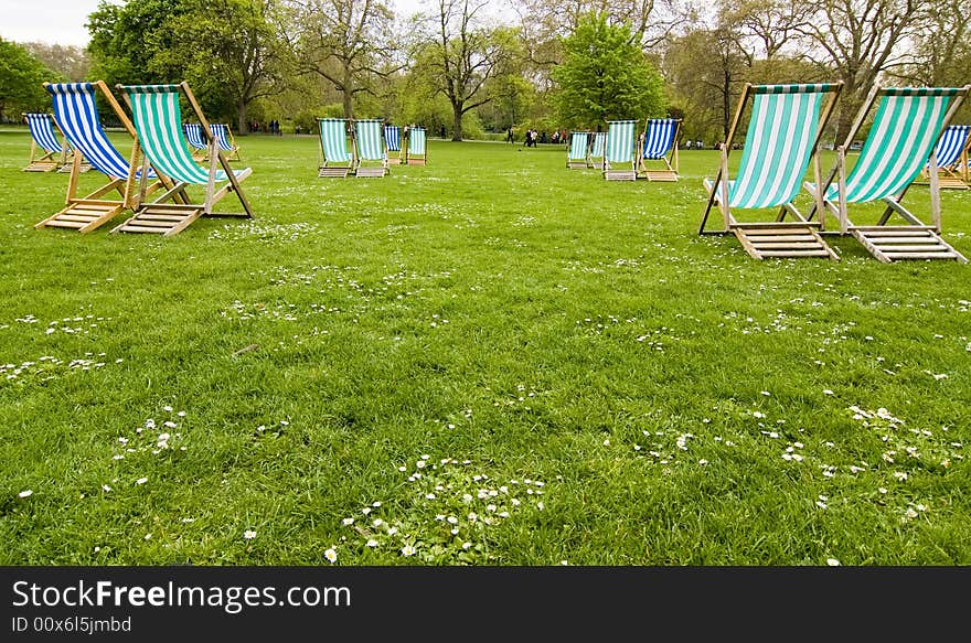 Empty deck chairs in British park.