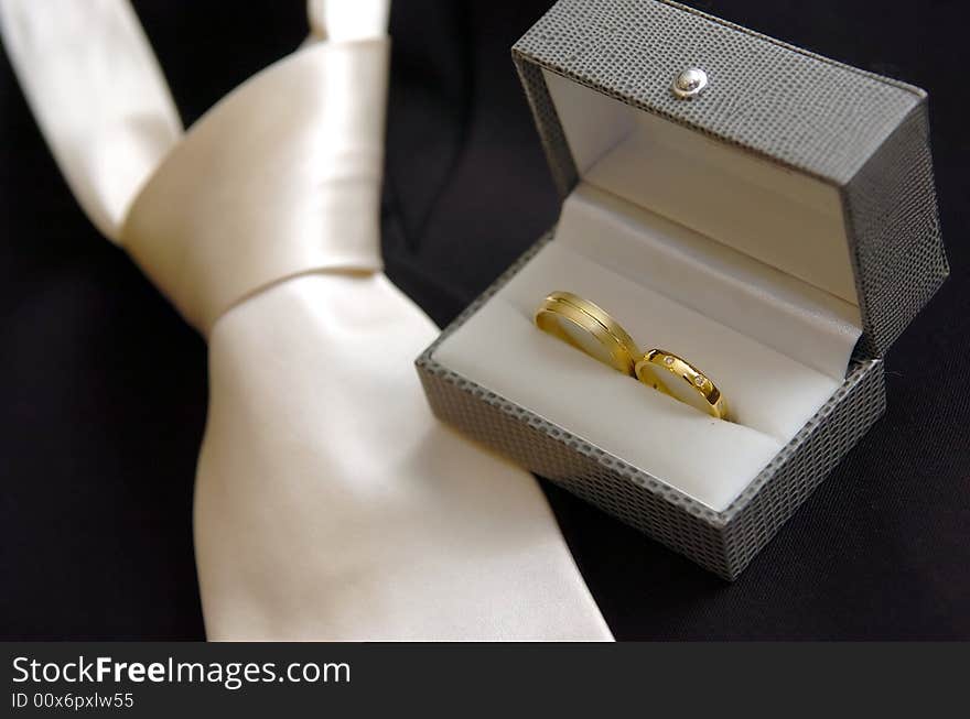 Close up photo of Wedding rings & wedding tie