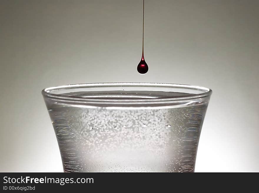 A single drop of blood into a clear class of water.  Blood may be thicker than water but there is always more water.