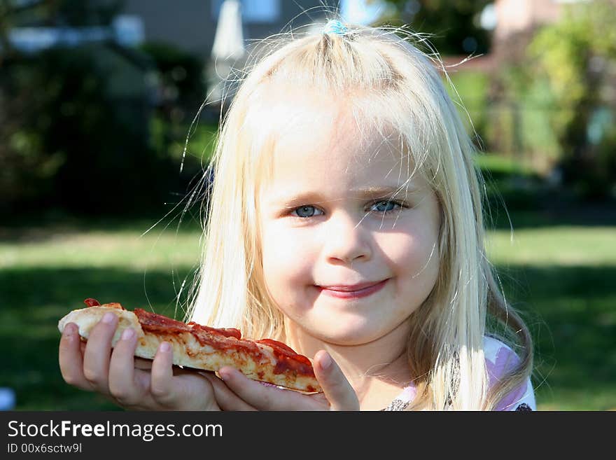 A little girl eating pizza slice