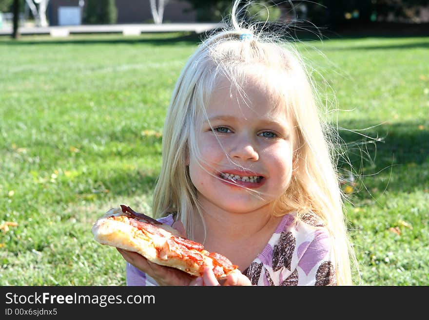 A little girl eating pizza slice