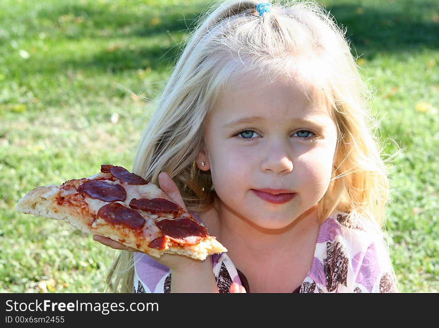 A little girl eating pizza slice