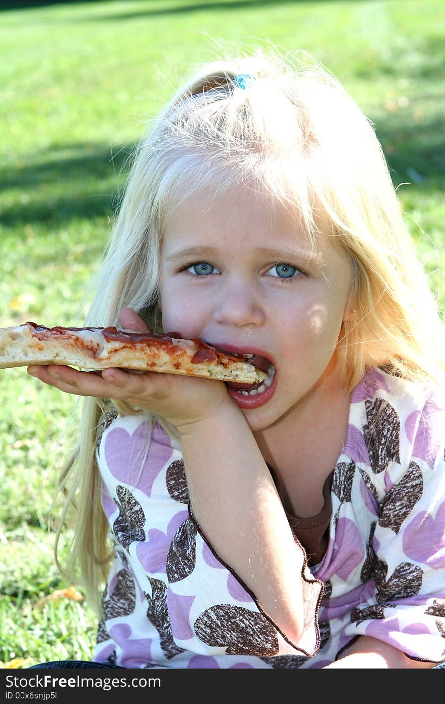 A little girl eating pizza slice