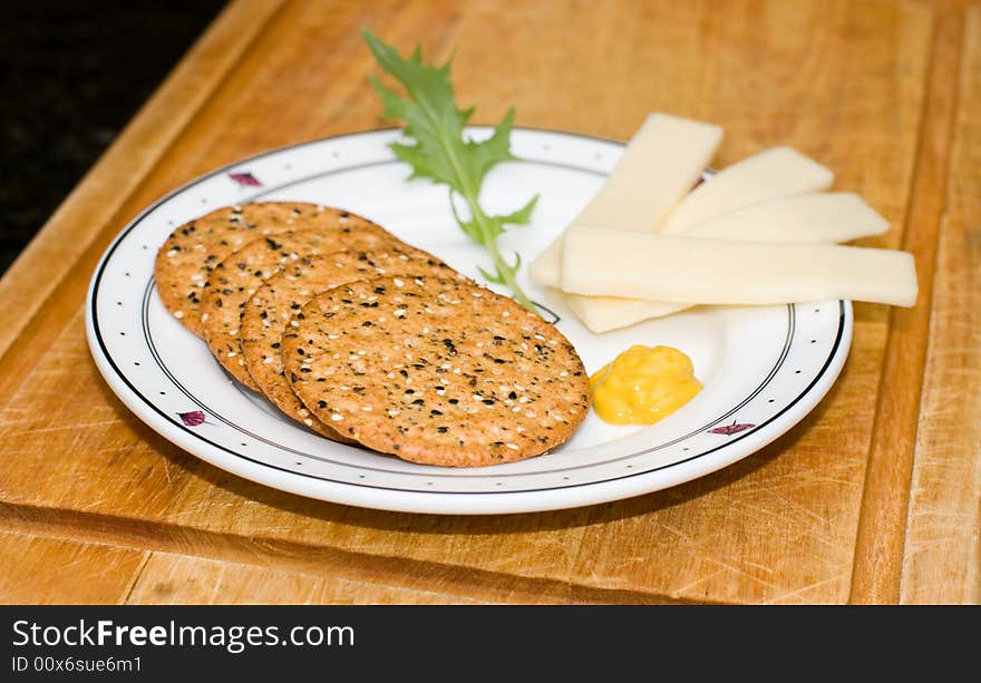 Plate of crackers and cheese with mustard and garnish. Plate of crackers and cheese with mustard and garnish