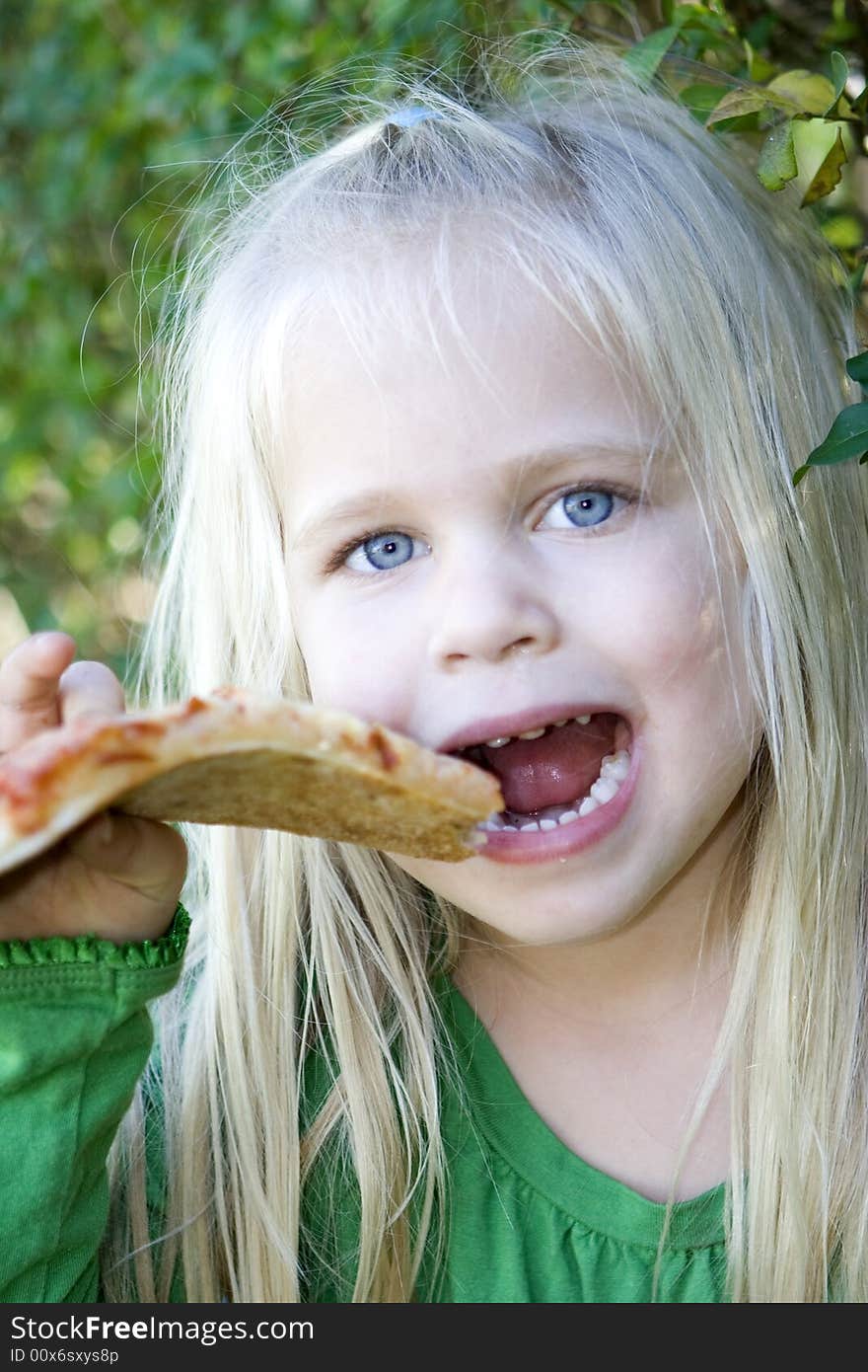 A little girl eating pizza slice