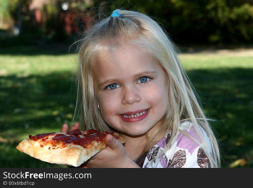 Sweet little girl eating pizza slice