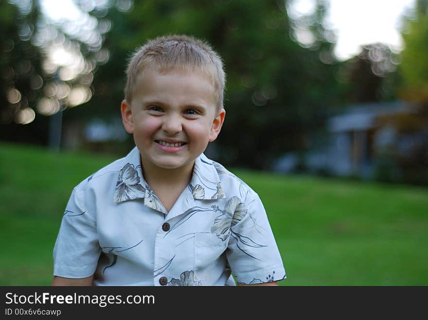 Young boy smiling and wearing Hawaiian shirt. Young boy smiling and wearing Hawaiian shirt