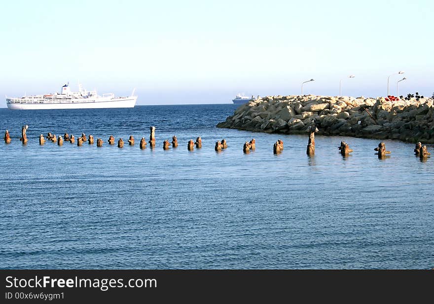 Old broken pier goes to the ship.