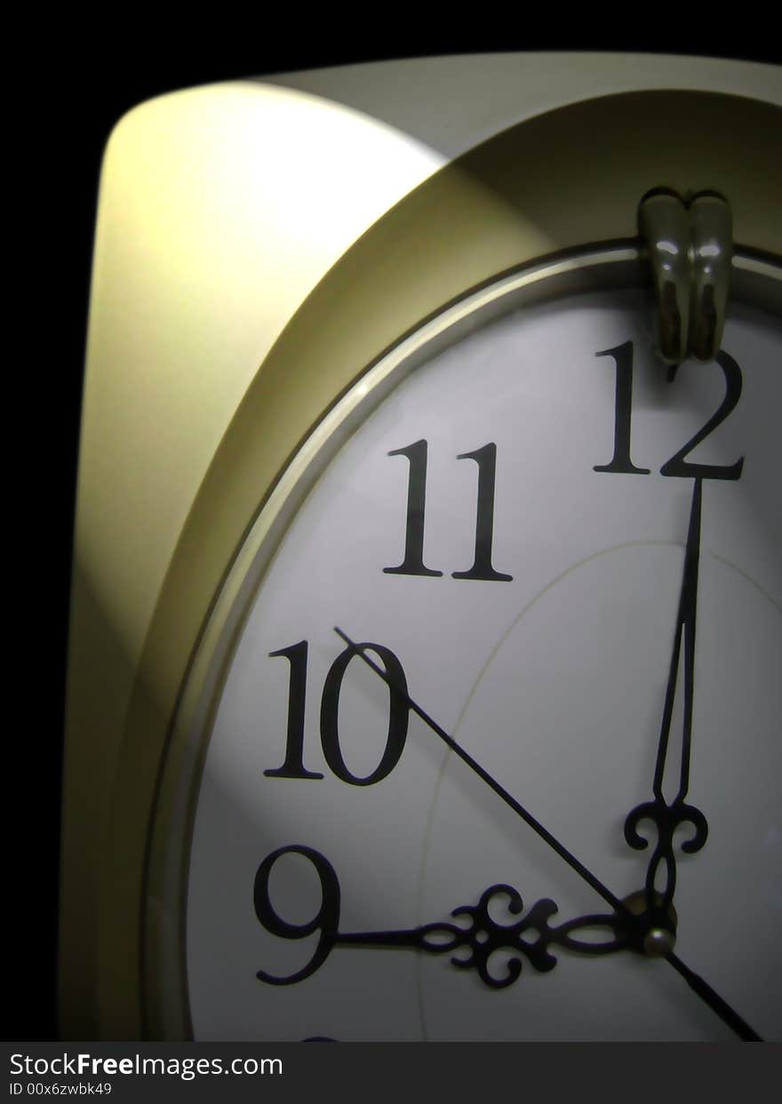 Clock on black background with a spotlight