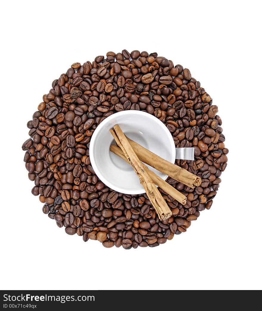 Coffee beans, white cup and cinnamon sticks isolated on white