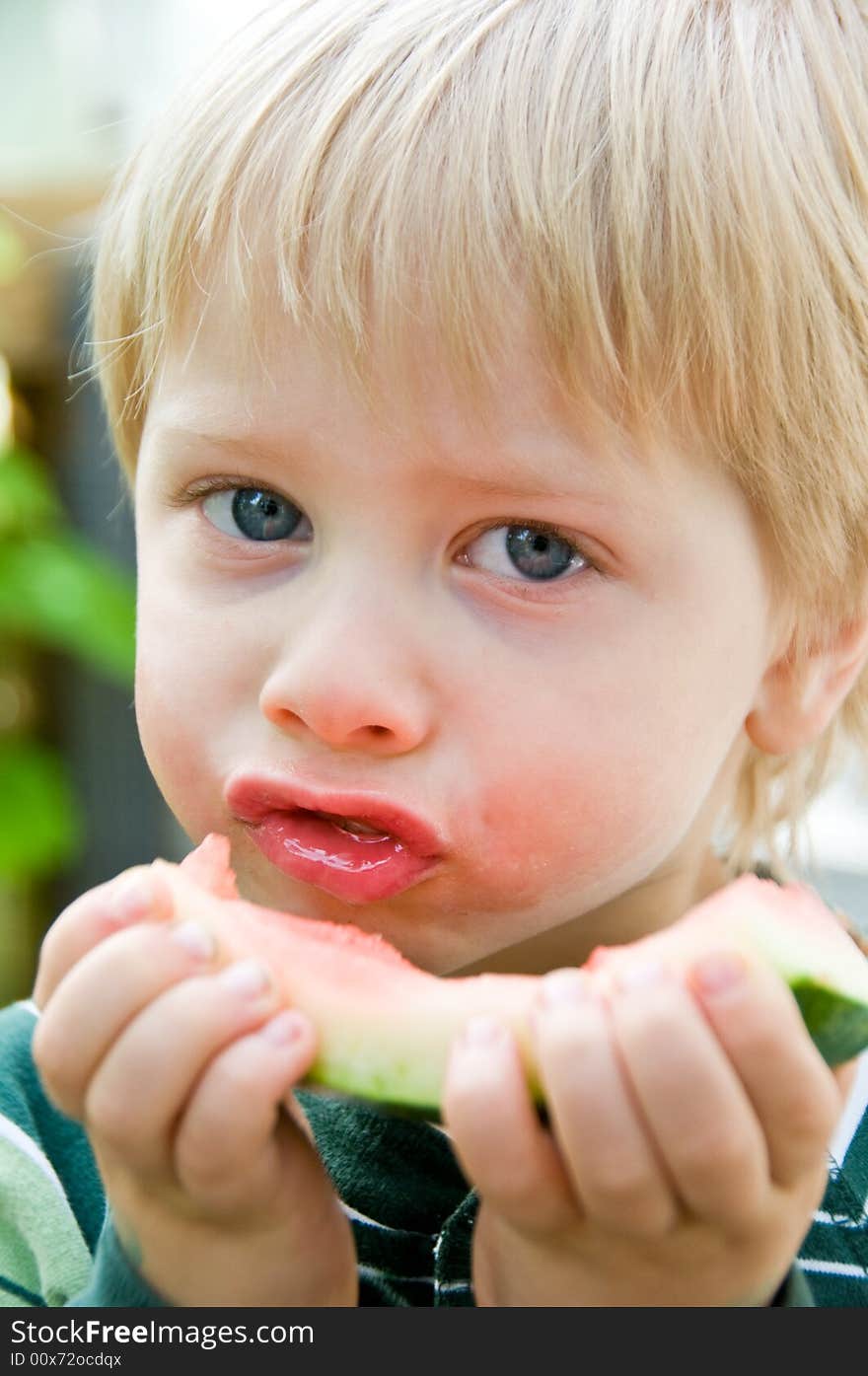 Cute boy savors the last bites of watermelon