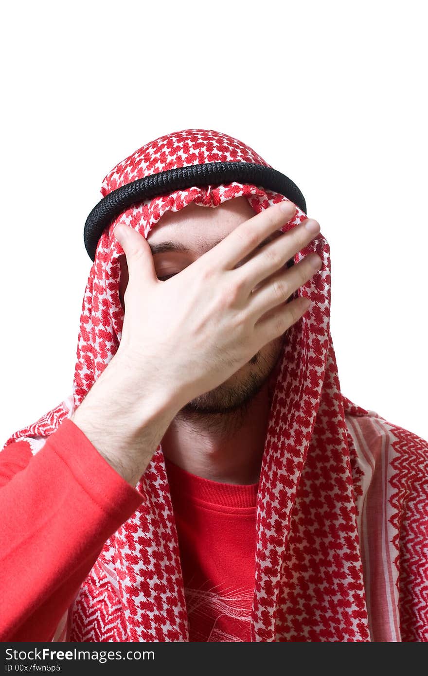 Portrait of an arabian young man in traditional headscarf - shemagh. He closed his face by hand palm.