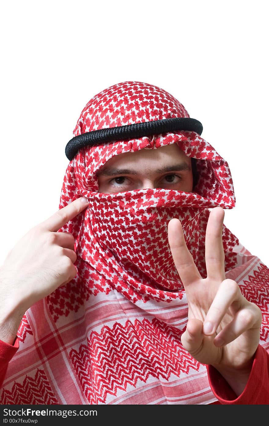 Portrait of an arabian young man in traditional headscarf - shemagh. He shows peace sign by hand.