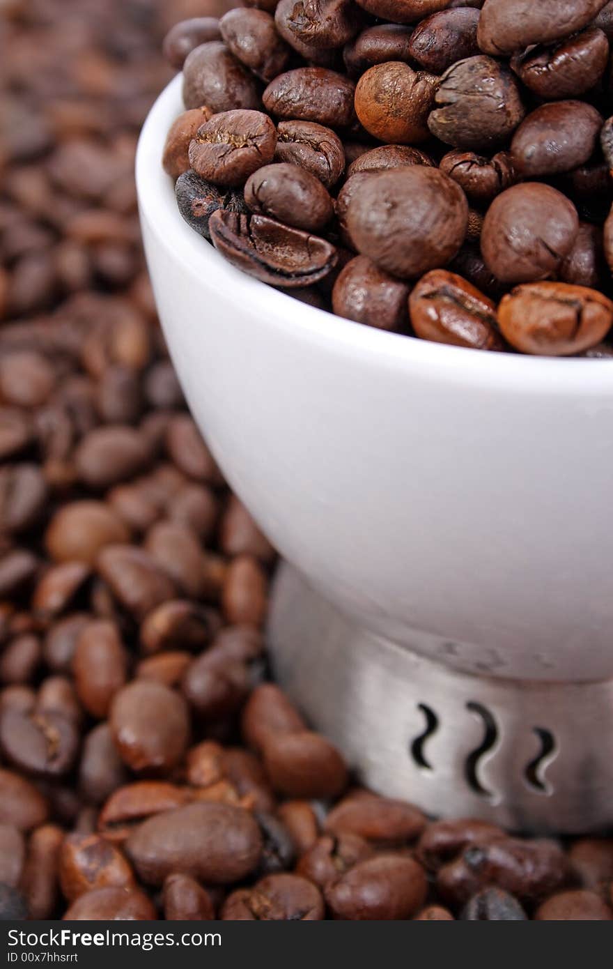 Cup of coffee beans on coffee beans background