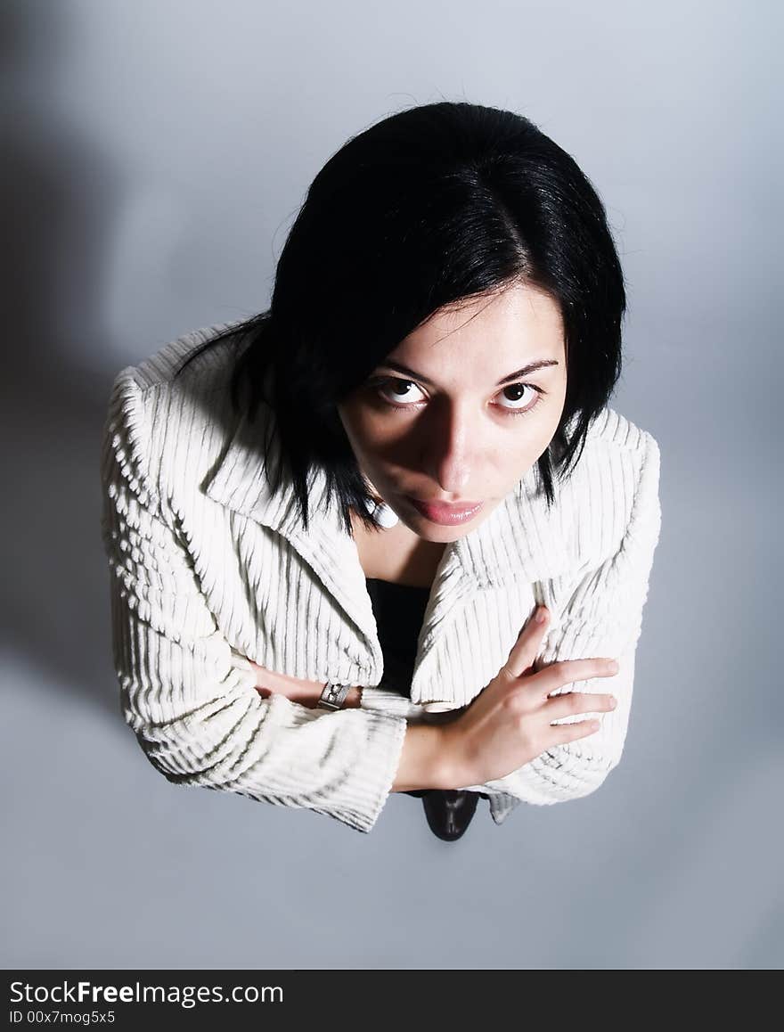 A high-key portrait about a young pretty lady with black hair who is looking up and dreaming. She is wearing a white coat and a black dress. A high-key portrait about a young pretty lady with black hair who is looking up and dreaming. She is wearing a white coat and a black dress.