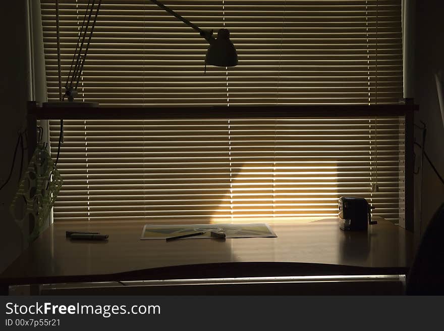 A drawing desk located by the windows with the blinds closed. A drawing desk located by the windows with the blinds closed.