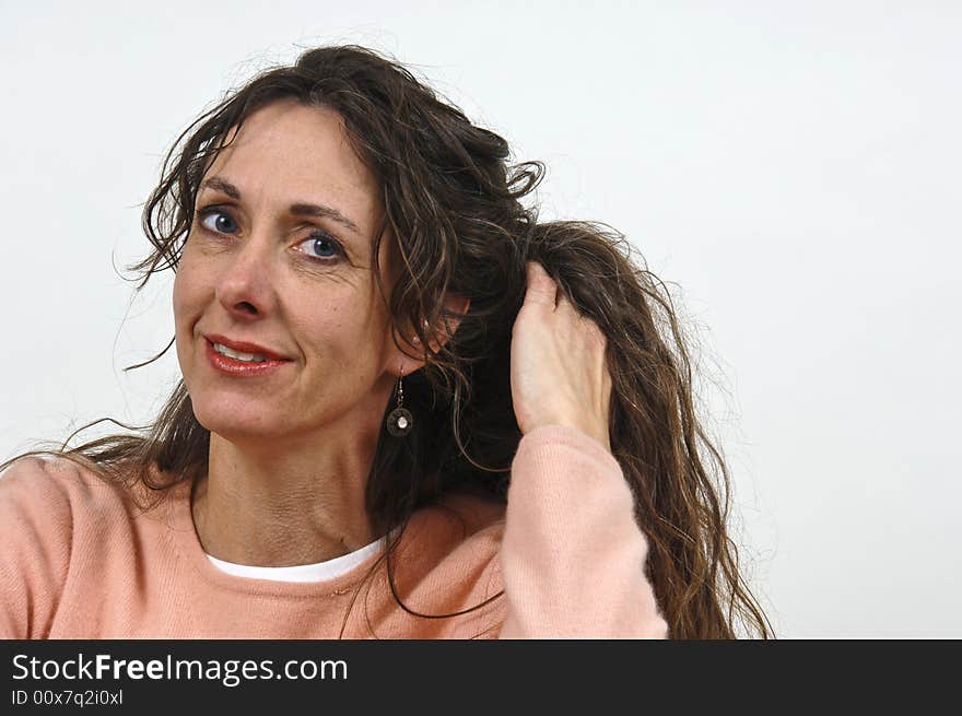 Attractive middle-aged caucasian woman with long brown hair, in a pink sweater. Attractive middle-aged caucasian woman with long brown hair, in a pink sweater.