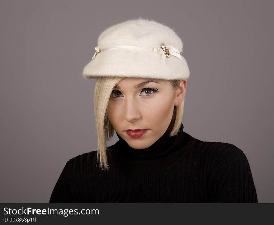 A blonde in a white fur hat with nice eyes. A blonde in a white fur hat with nice eyes