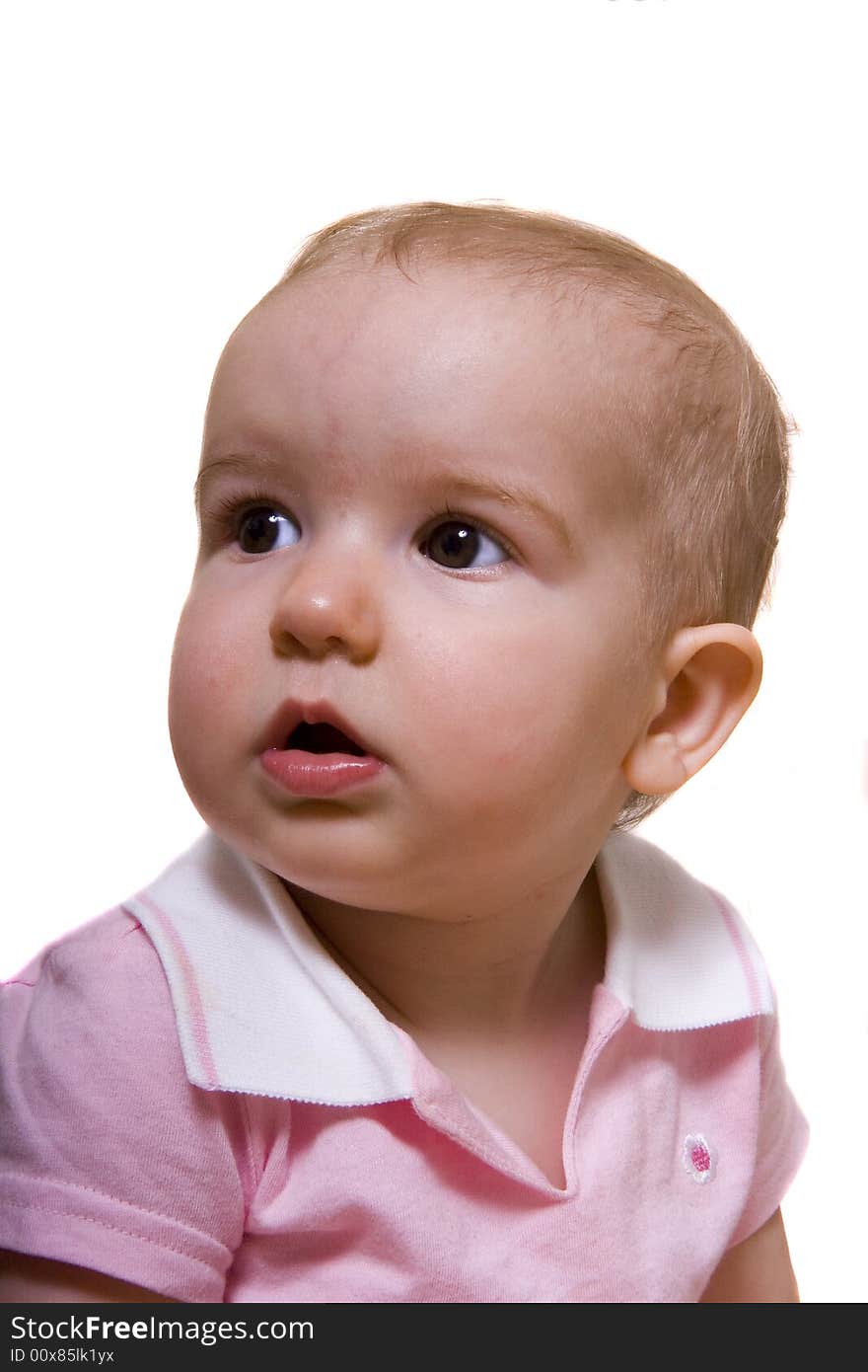 A young baby in pink looking off to the right. A young baby in pink looking off to the right