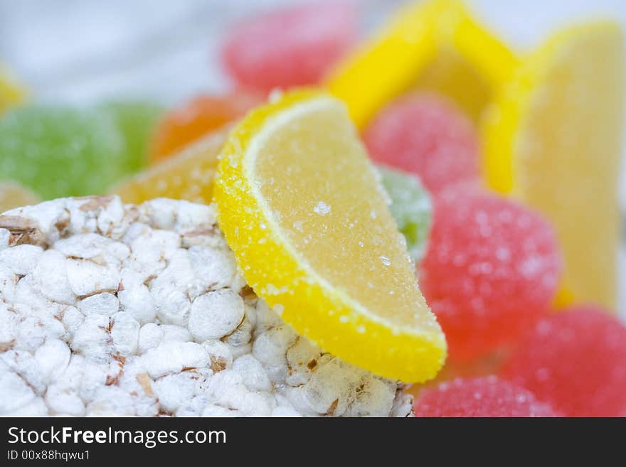 Small loaf of bread and heap of colorful dried sugared fruits. Small loaf of bread and heap of colorful dried sugared fruits