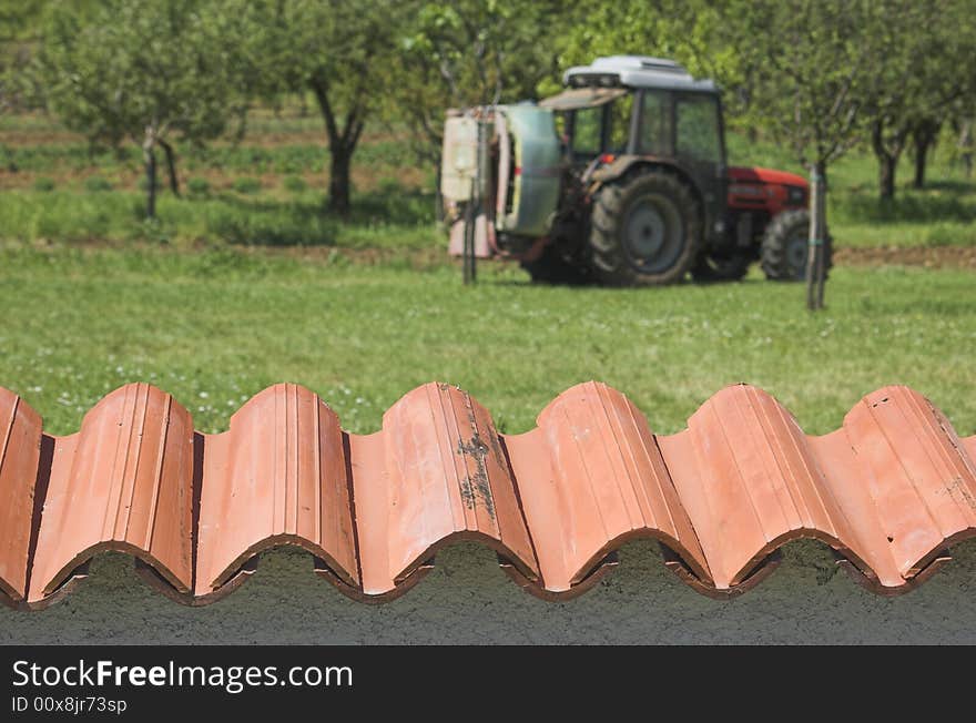 Agricultural tractor photographed from behind a garden wall