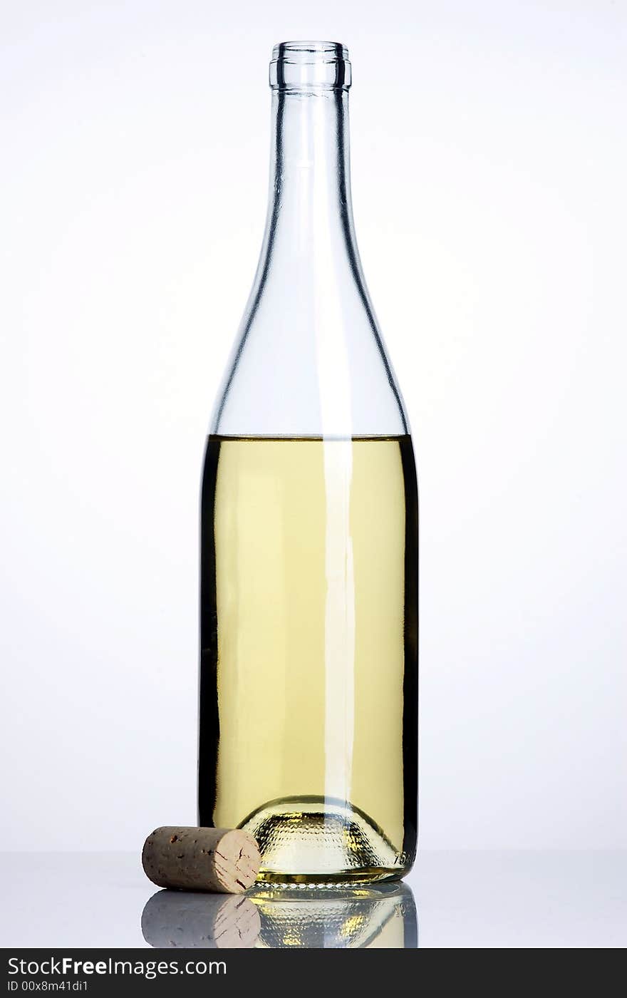 Opened bottle of white wine with cork on white backround