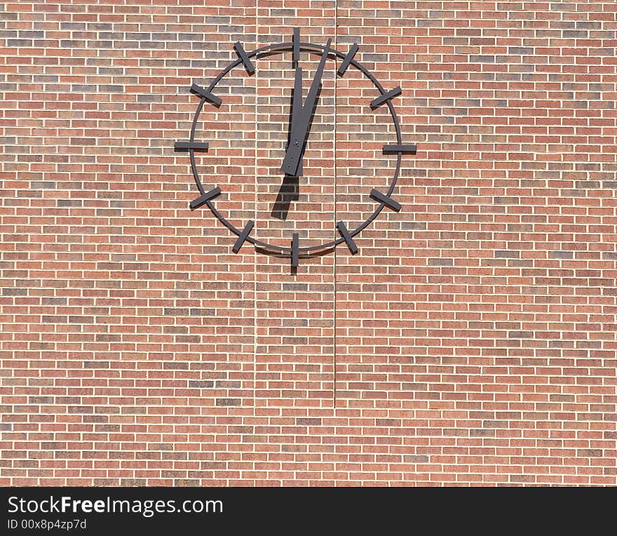 A clock just after noon on a brick wall. A clock just after noon on a brick wall