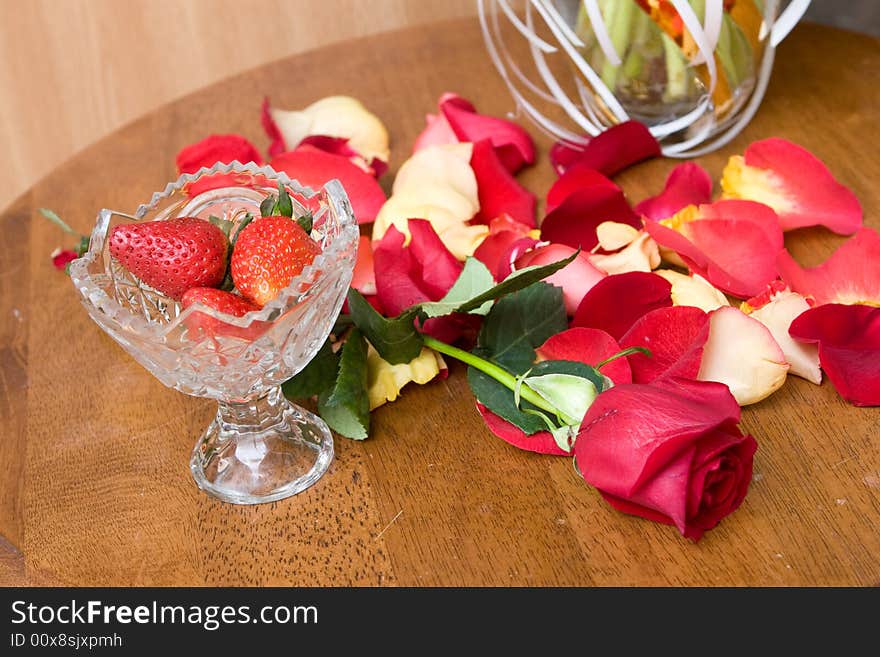 Beautiful red tulip petals ans strawberry in bowl on the table. Beautiful red tulip petals ans strawberry in bowl on the table