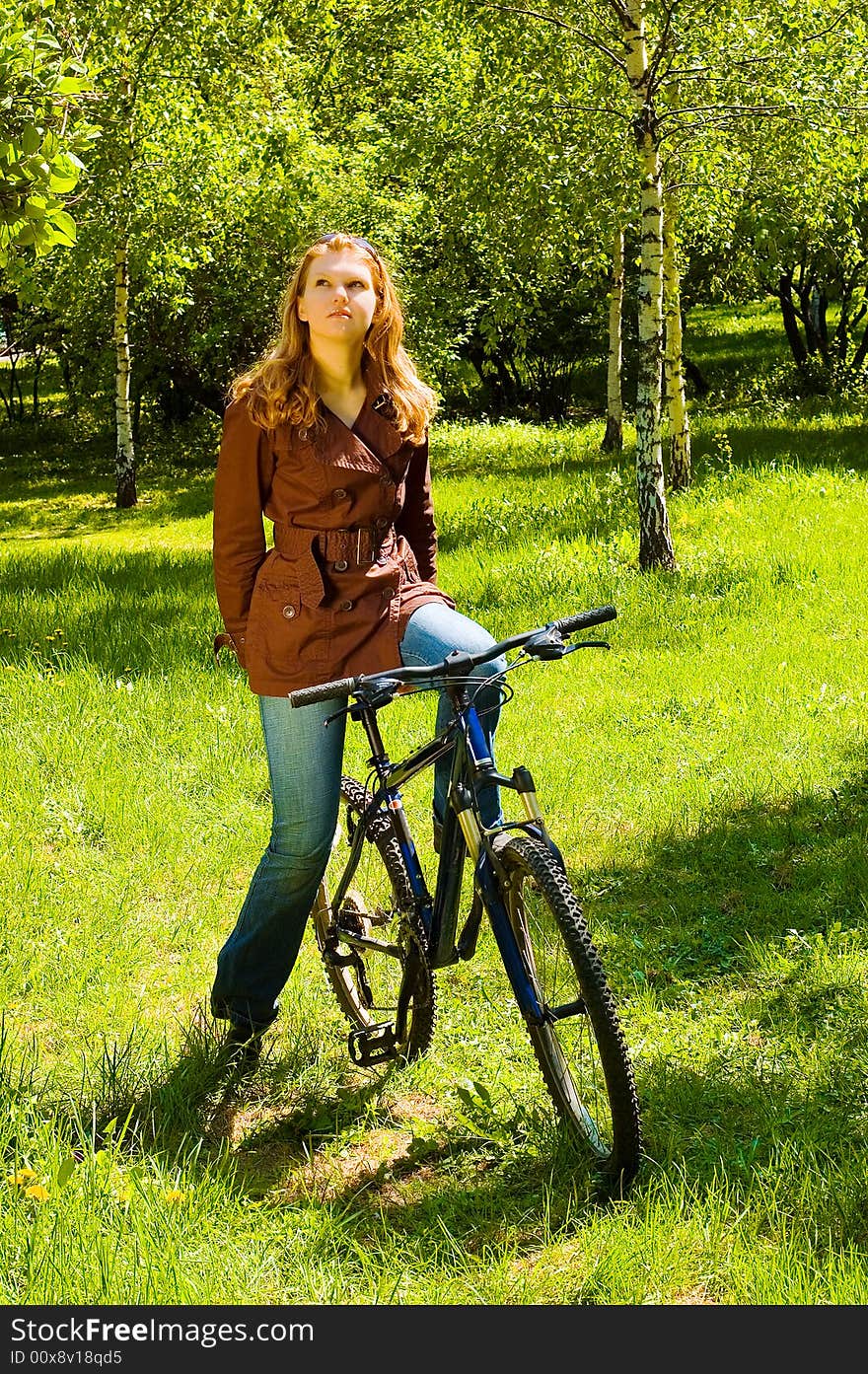 Young woman on bicycle in the spring forest