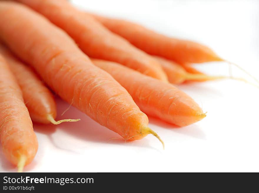 A bunch of fresh organic carrots, on a white background.