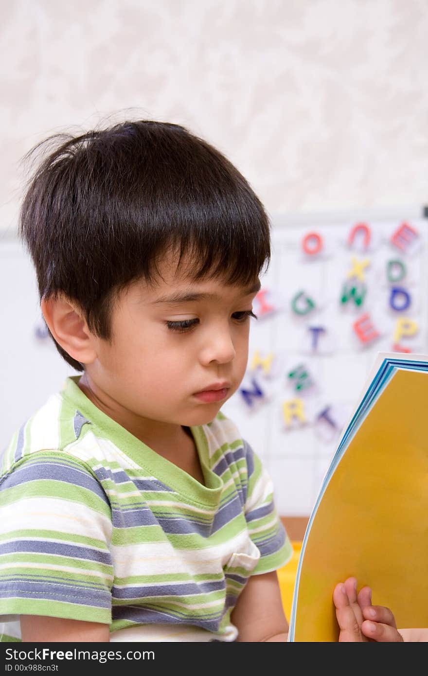 Little boy showing interest in reading book. Little boy showing interest in reading book.