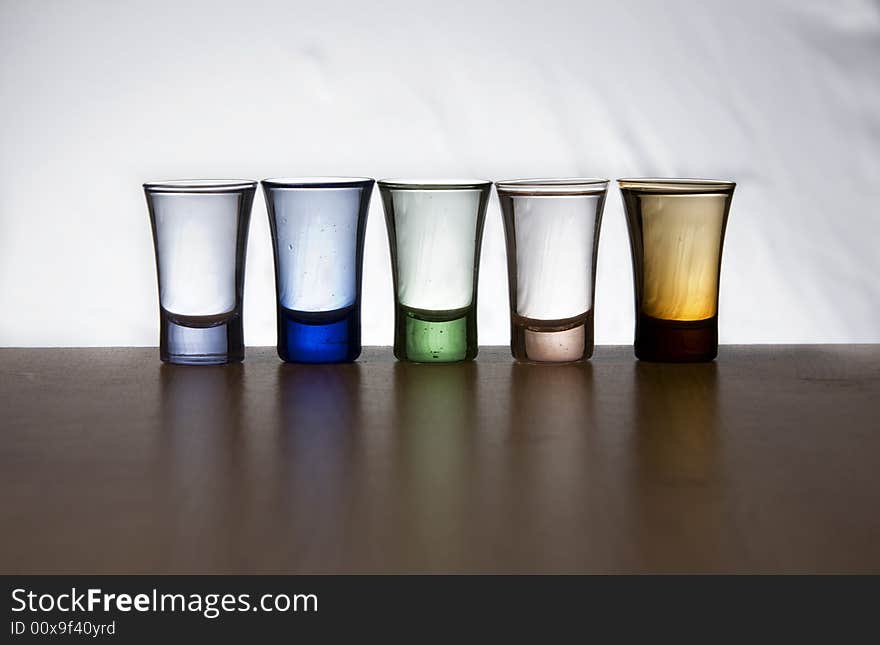 Five shots of alcohol with reflexion in the table