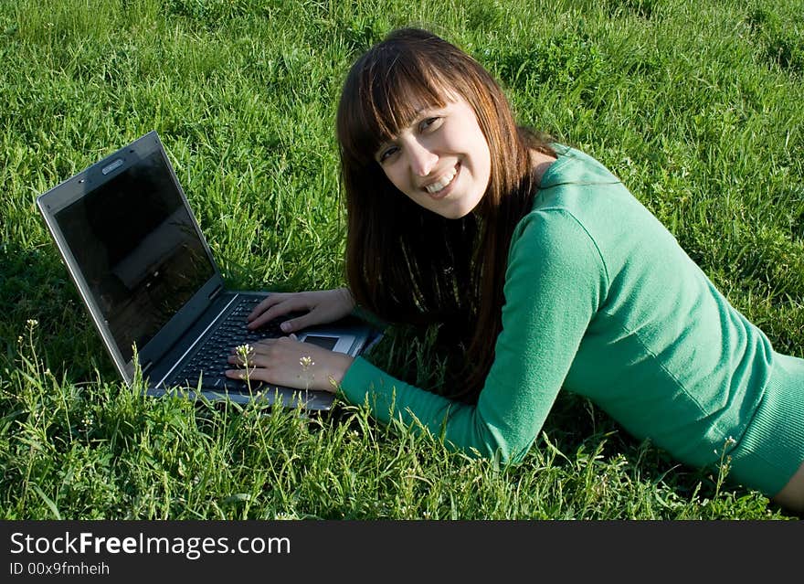 Smiling girl with laptop outdoor