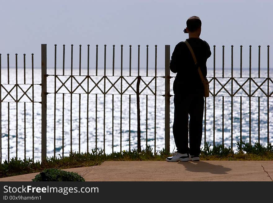 Young man taking photo at the Mediterranean Sea