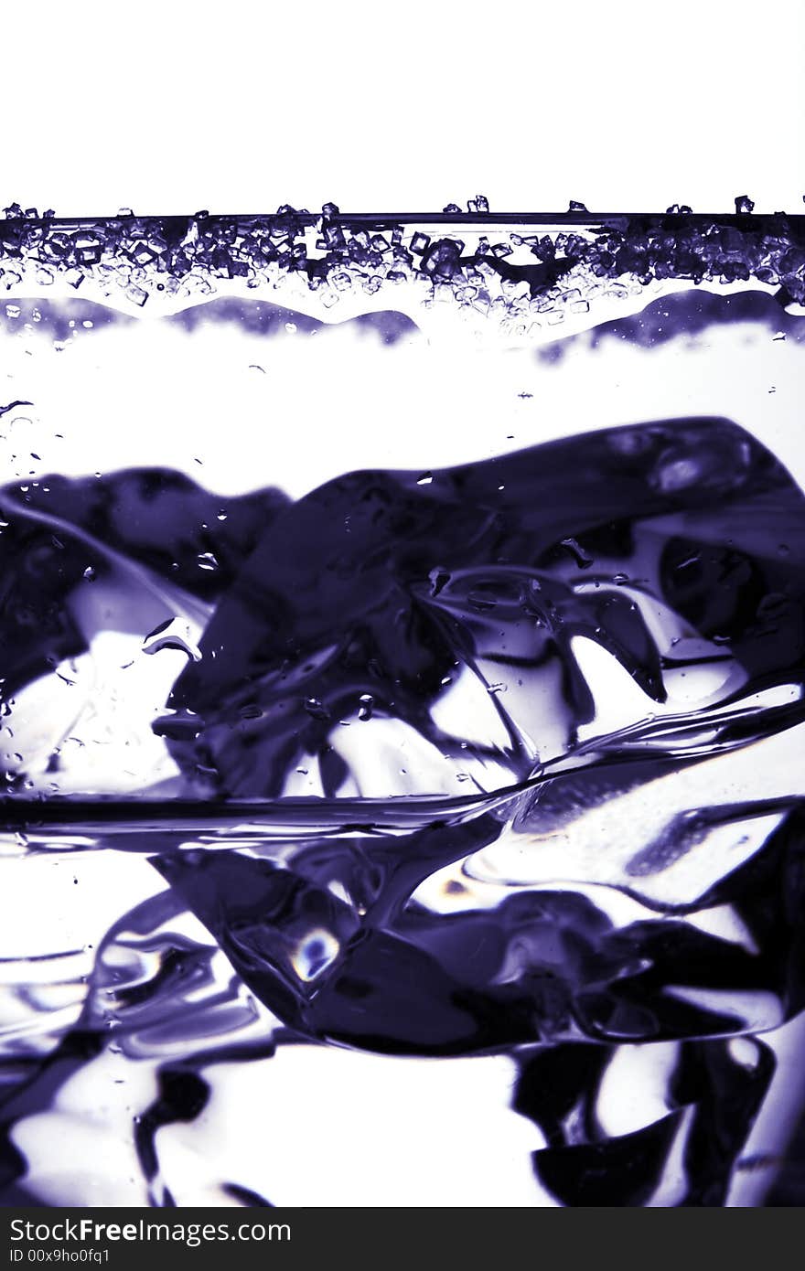 Clear glass with ice, sugar and some drink, deep blue color, super close-up shot