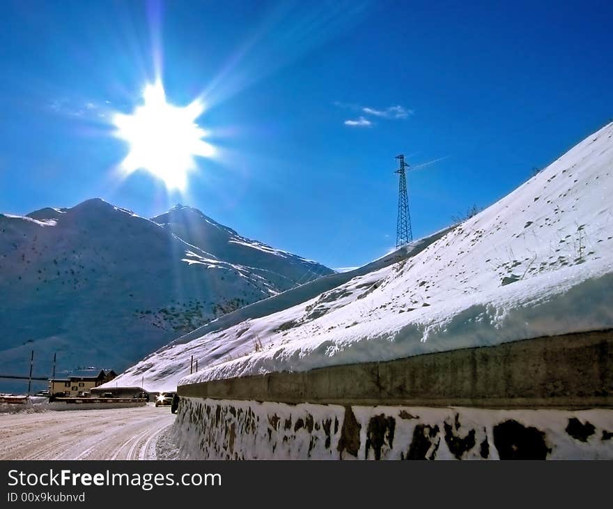 The sun is shining over a mountain full of white snow. The sun is shining over a mountain full of white snow