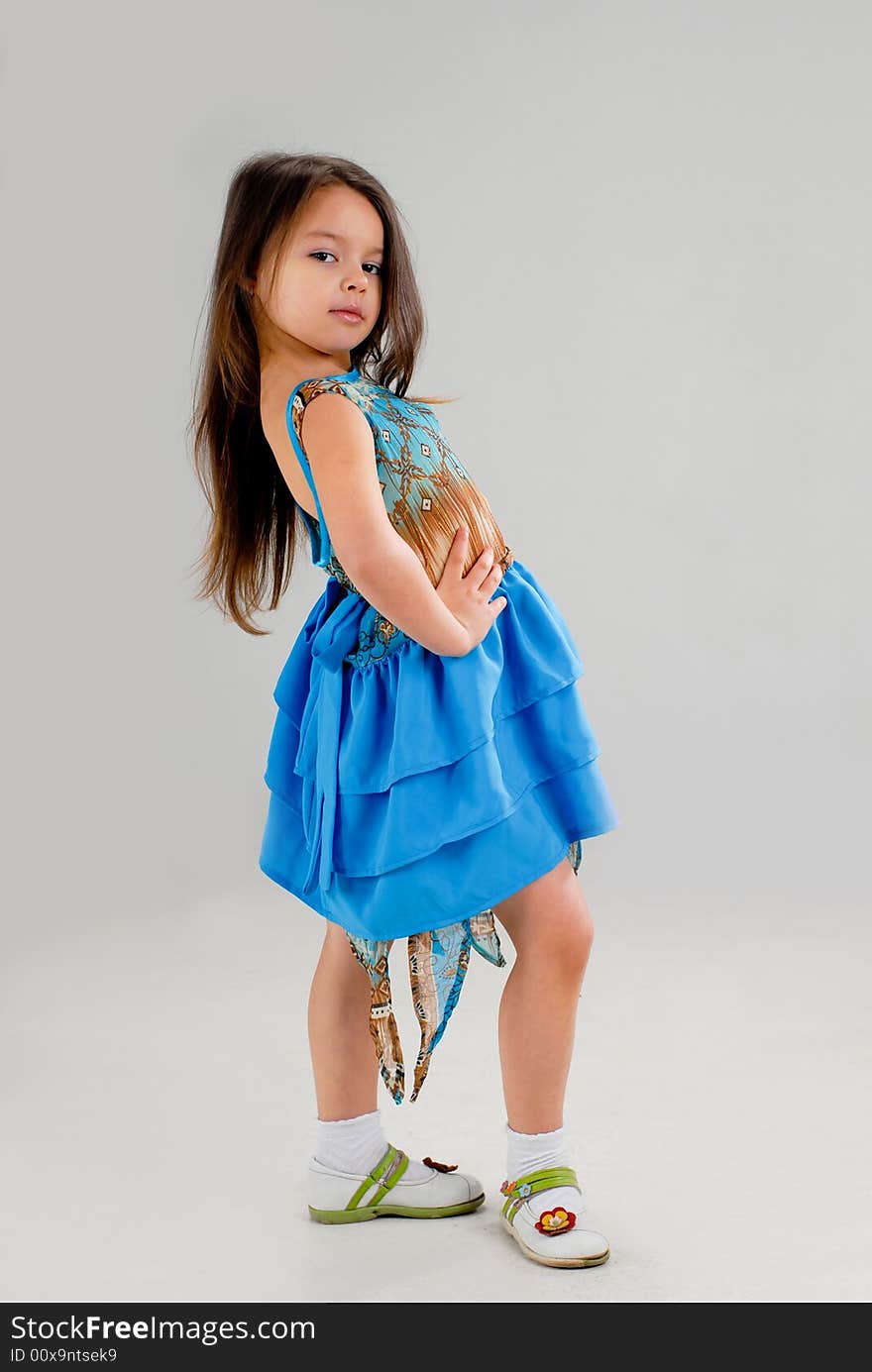 Little cute girl posing in a fancy blue dress. Little cute girl posing in a fancy blue dress