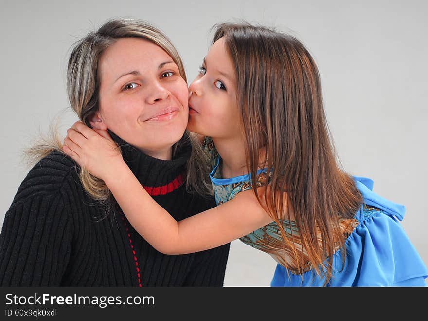 Cute little baby girl kissing her mom with love. Cute little baby girl kissing her mom with love